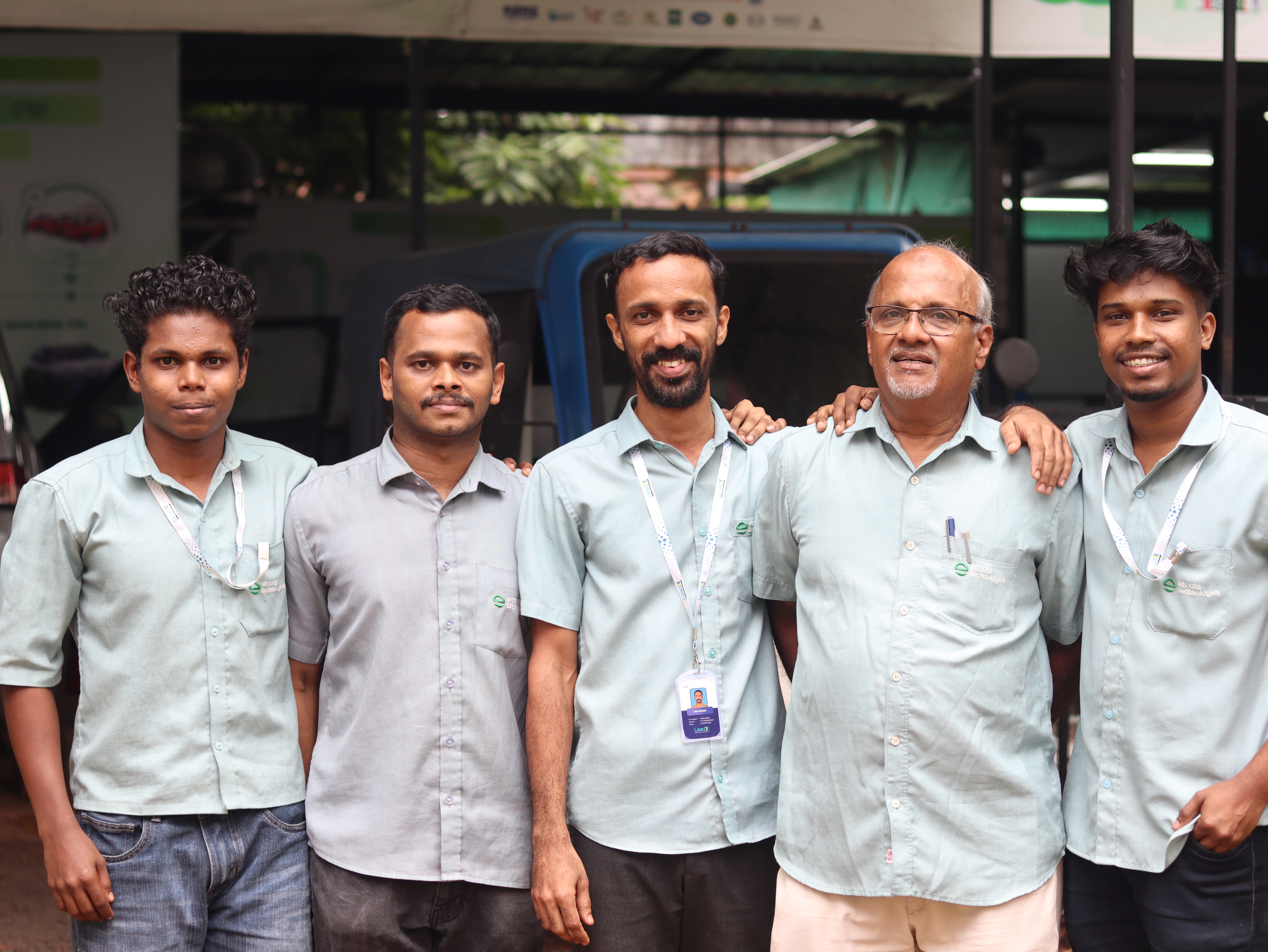 Eroots Technologies team members standing together in workshop uniform.