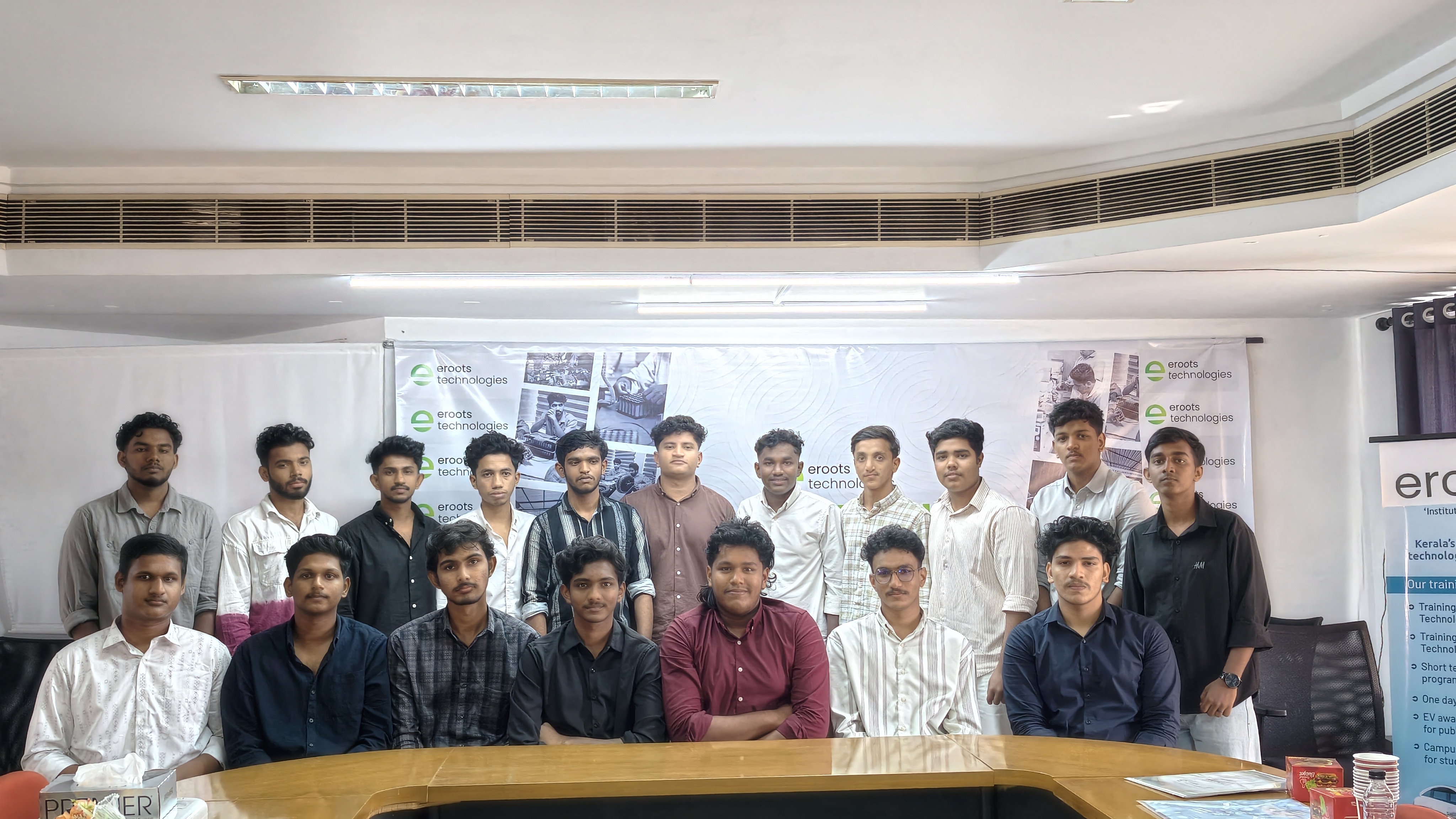 Student group portrait inside Eroots Technologies event hall.