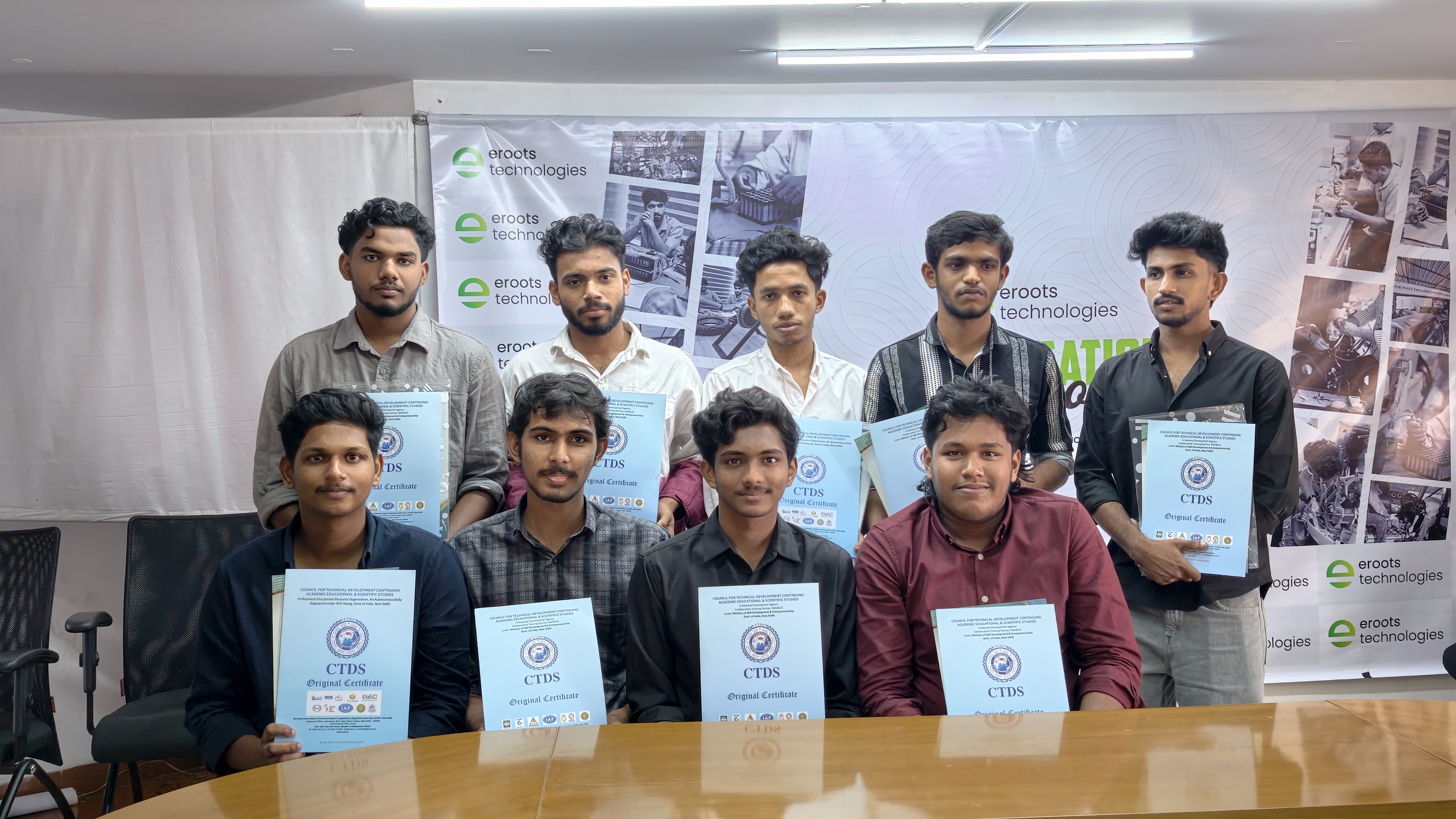 Students posing with certificates after program completion.